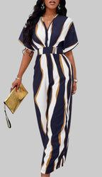 Woman wearing a navy and white striped dress with a belt, holding a yellow clutch.