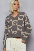 Sarah Express women’s cropped V-neck sweater in a grey and cream heart and paw print checkerboard pattern.
