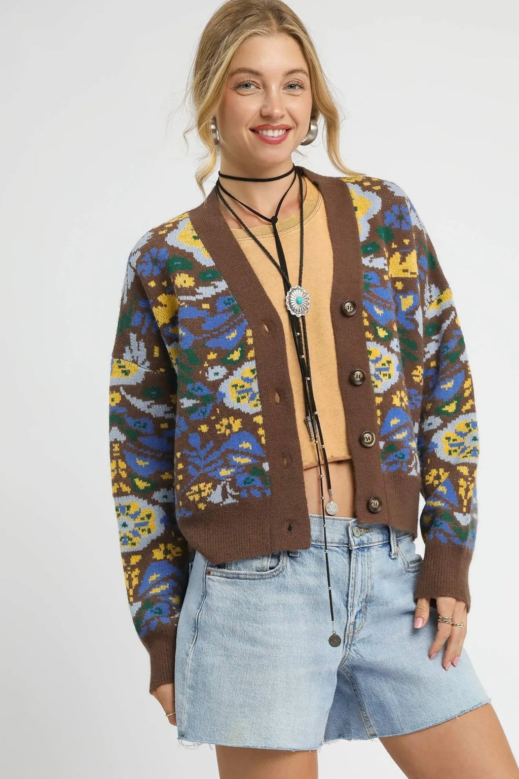 Woman wearing a patterned cardigan with a plain background