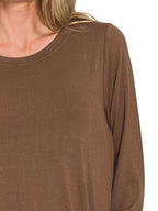 Brown long-sleeve top worn by a person on a white background