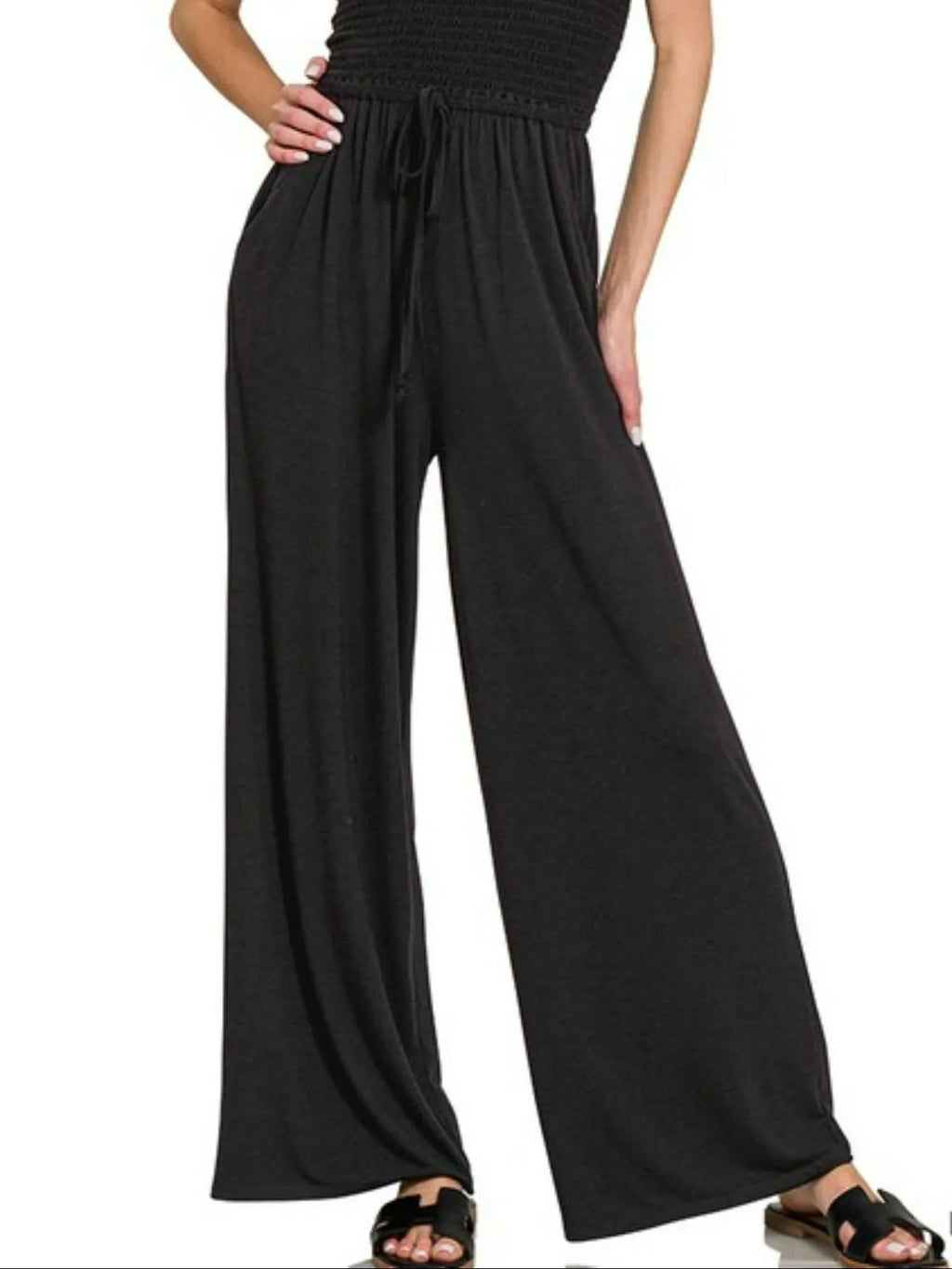 Black wide-leg pants worn by a person on a white background